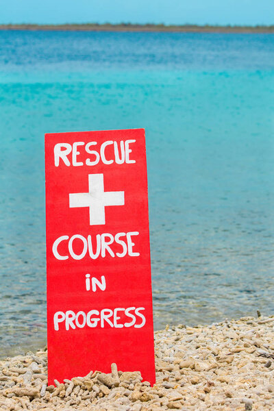 Red warning sign for rescue exercise near sea