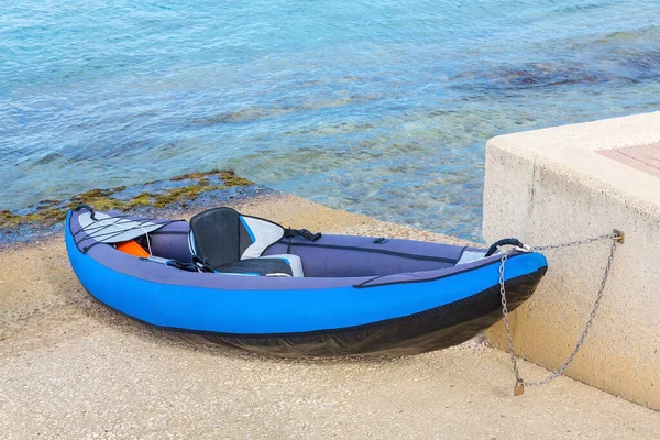 Canoa Azul Encadenada Estacionada Orilla Con Agua Mar —  Fotos de Stock