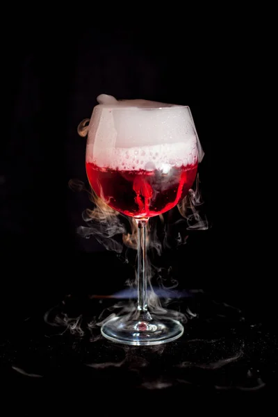 Una taza de cóctel rojo frío con humo de hielo seco — Foto de Stock