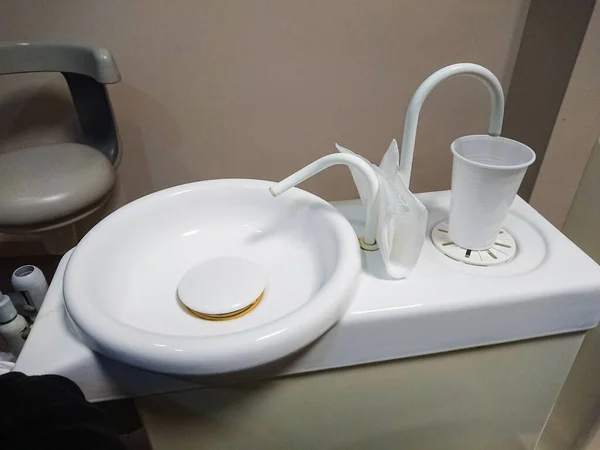 Waschbecken mit Glas Wasser beim Zahnarzt — Stockfoto