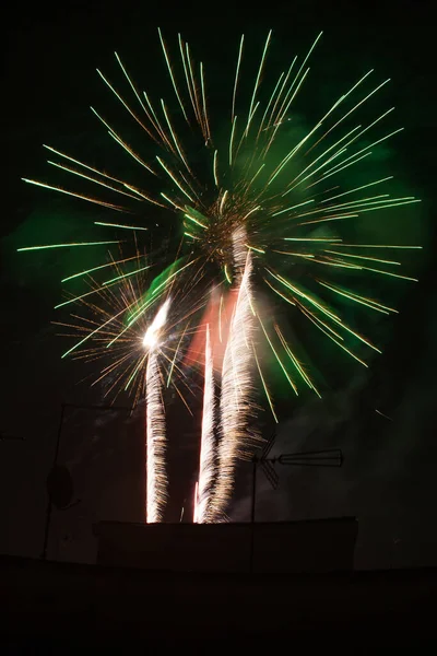 Colorful fireworks at night over buildings in the city - happiness concept