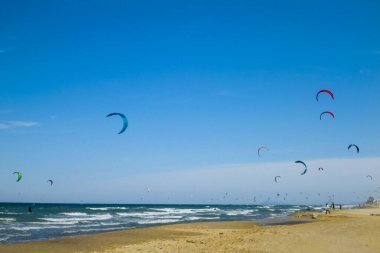 Mavi gökyüzüyle sahilde uçurtma sörfü