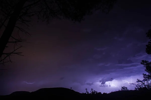 Thunderbolts over the mountains with blue and purple sky
