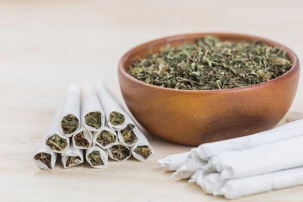 Marihuana, ot ya da esrar yakın çekim ahşap kase ve sarılmış esrar.