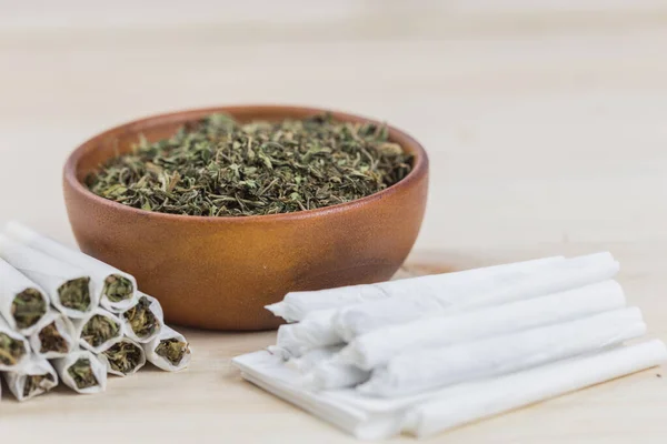 Ahşap kasede marihuana ve esrar sarmak için sarma, kırsal ahşap arka planda.