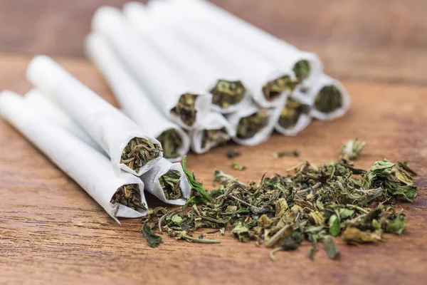 Yüksek kalitede güçlü kenevir ve ahşap masada esrar ile sarılmış esrarı kapatın. Seçici Odaklanma.