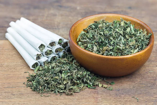 Marihuana, ot ya da esrar yakın çekim ahşap kase ve sarılmış esrar.