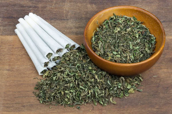 Marihuana, ot ya da esrar yakın çekim ahşap kase ve sarılmış batakhane. Üst viwe.