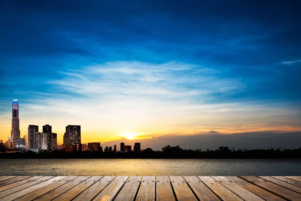 Pasarela de madera sobre fondo de ciudad y puesta de sol — Foto de Stock