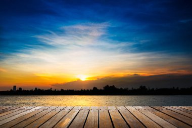 Gün batımı arka plan üzerinde ahşap yürüme yolu