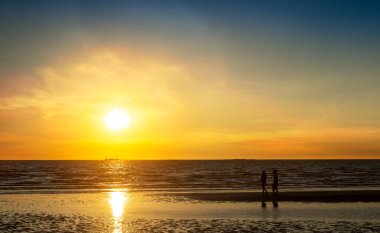 Gün batımında sahilde yürüyen çift, romantik aşıklar konsepti.