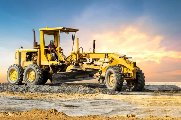 Günbatımı arka planında endüstriyel motor derecelendirici, Dünya hareket eden motor ekipmanı