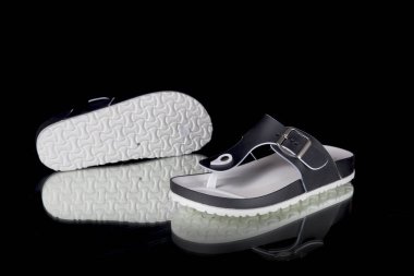 Kadın siyah ve beyaz lastik terlik siyah arka plan üzerine