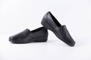 Beyaz arka planda siyah deri kadın ayakkabı