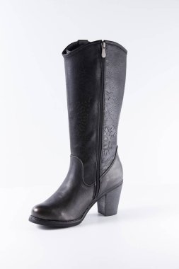 Beyaz arka plan üstünde kadın siyah deri çizme