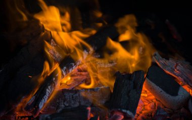 Sarı ve turuncu alev topu, siyah arkaplanı ısıtıyor..