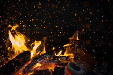 Sarı ve turuncu alev topu, siyah arkaplanı ısıtıyor..