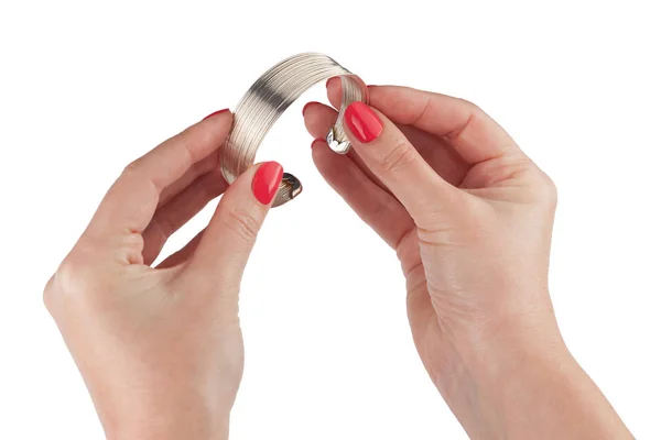 Mãos femininas com manicure vermelho segurando uma pulseira — Fotografia de Stock
