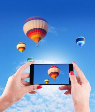 Akıllı tutan eller fotoğraf mavi gökyüzünde sıcak hava ile telefon