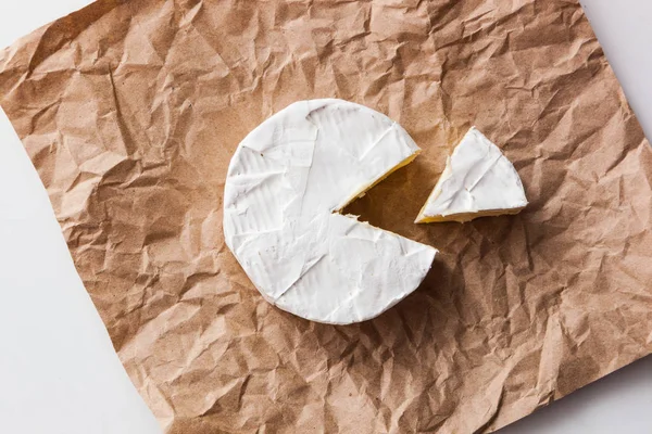 Fresh slice Camembert cheese natural, on Kraft paper
