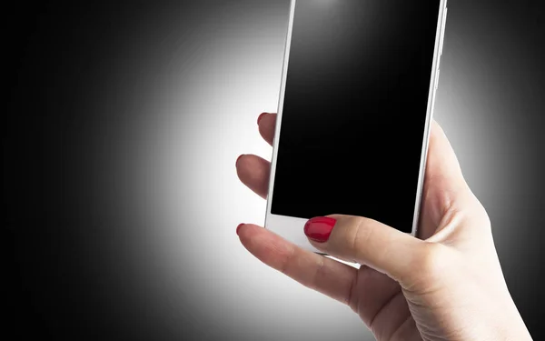 Рука женщины держит и трогает смартфон, изолированный на черном — стоковое фото