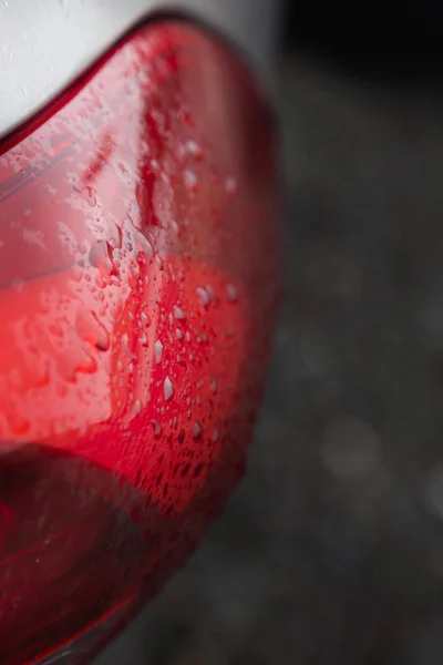 Dešťové kapky na červené auto světlometů — Stock fotografie