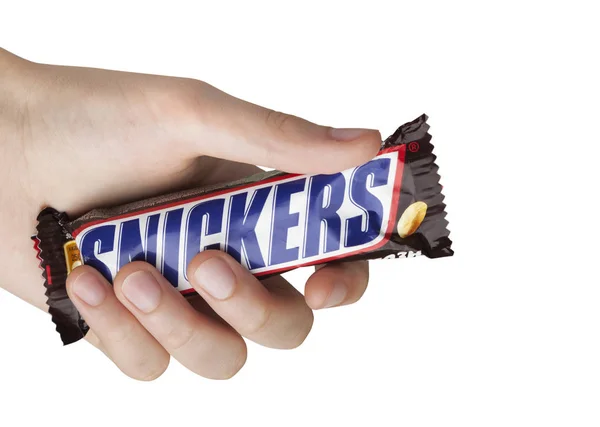 Bir Snickers çikolata bar tutan el — Stok fotoğraf