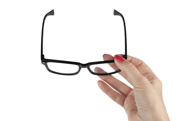 Female hand holding a black-framed glasses isolated on white bac — Stock Photo, Image