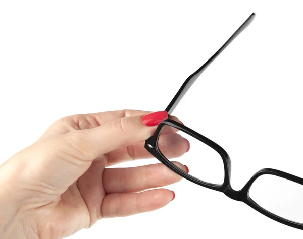 Weibliche Hand mit einer schwarz gerahmten Brille isoliert auf weißem Bac — Stockfoto