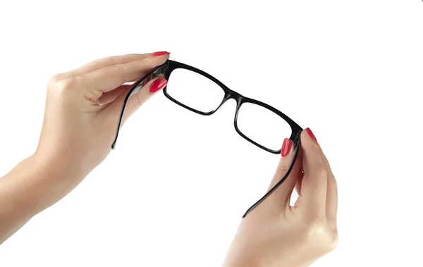 Mano femenina sosteniendo unas gafas de marco negro aisladas en bac blanco —  Fotos de Stock