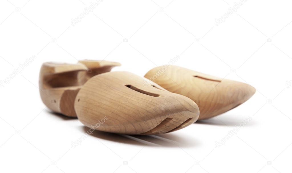 Selective focus of men's wooden shoe stretcher isolated on a white background