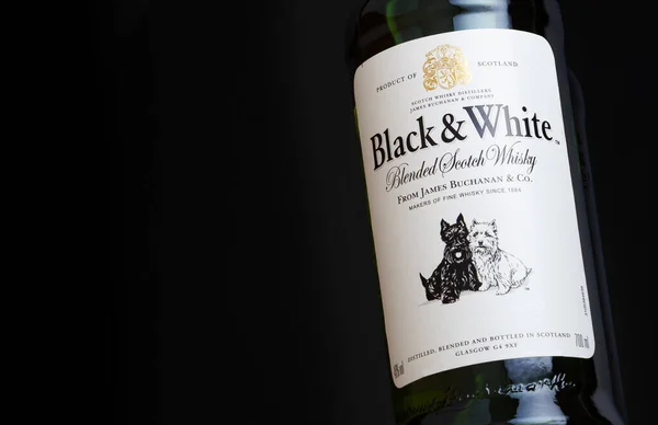 CHISINAU, MOLDOVA - 27 Nisan 2020: Siyah ve beyaz karışımlı viski şişesi etiketi siyah arkaplanda. Orijinal yapımcısı London James Buchanan Co Ltd. Black and White şimdi Diageo 'ya ait..