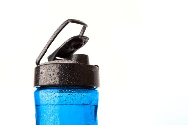 Plastik mavi spor şişesi damlacıklarla kaplı. Beyaz arkaplanda izole.