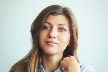 Mavi bir arka plan üzerinde uzun siyah saçlı genç kız yüz