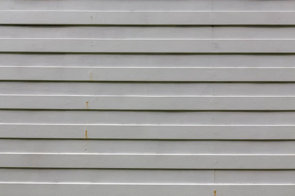 Weißholzlatte. gerade gestreiftes Whiteboard. Hauswand außen — Stockfoto