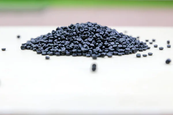 Nahaufnahme von Kunststoff-Polymergranulaten. Polymerpellets auf Holz — Stockfoto