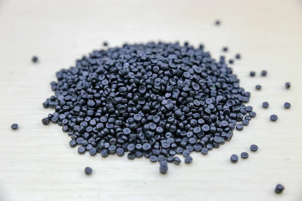 Närbild av plastpolymergranulat. Polymerpellets på trä — Stockfoto