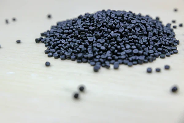 Close-up of plastic polymer granules. Polymer pellets on Wooden