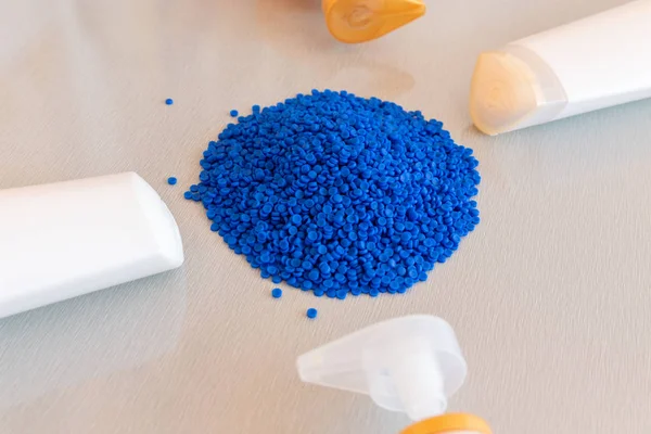 Close-up of plastic polymer granules and plastic bottle. Polymer