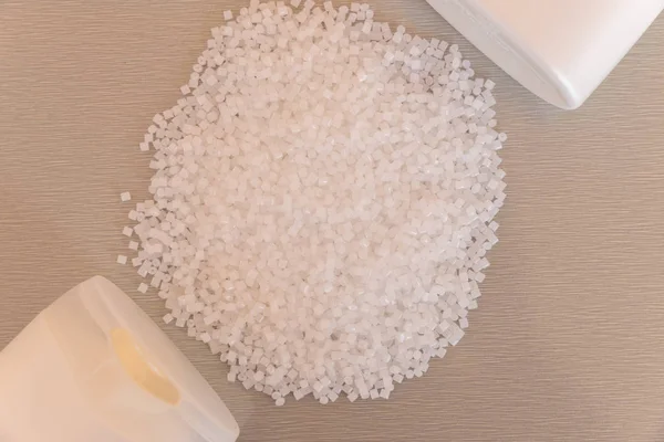 Primer plano de gránulos de polímero plástico y frasco de plástico. Polímero — Foto de Stock