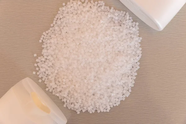 Gros plan sur les granules de polymère plastique et la bouteille en plastique. Polymère — Photo