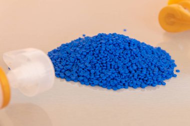 Plastik polimer granüller ve plastik şişe yakın çekim. Polimer