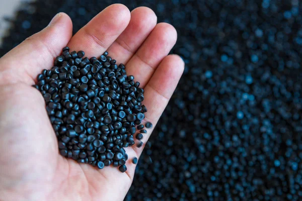 Close-up of plastic polymer granules. hand hold Polymer pellets.