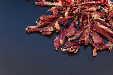 Siyah arka planda güneşte kurutulmuş biftek. Yemek için kurutulmuş domuz eti. D