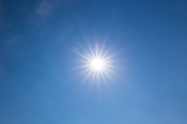 Açık mavi gökyüzünde parlayan güneş. Mavi gökyüzü arka planında güneş ışığı parlıyor. Mavi gökyüzünde parlak güneş.