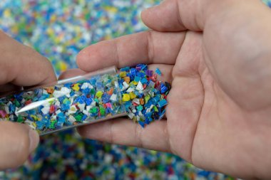 Plastik polimer granüllere yakın çekim. Polymer topaklarıyla el ele tutuşun. Polimer plastik. bileşik polimer.