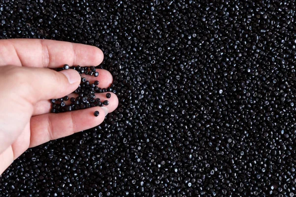 Close-up of plastic polymer granules. hand hold Polymer pellets. polymer plastic. compound polymer.