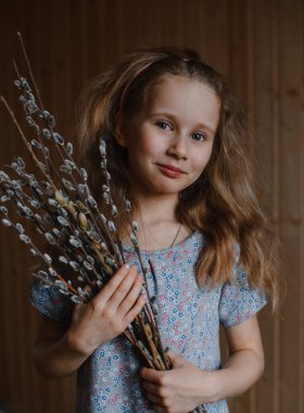 Güzel, mutlu, gülümseyen beyaz tenli, uzun sarı saçlı, gri gözlü, söğüt dallı, ahşap elbiseli kız.