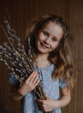 Güzel, mutlu, gülümseyen beyaz tenli, uzun sarı saçlı, gri gözlü, söğüt dallı, ahşap elbiseli kız.