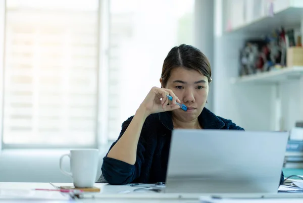 Asyalı kadın bir dizüstü bilgisayarla çalışırken ya da evde telekonferans yaparken çok çalıştı. CV19 virüslü iş kadınının evde çalışması ya da işten sonra bilgisayar başında dinlenmesi ya da sıkılması nedeniyle..
